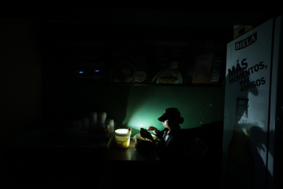 Comercio. Una trabajadora de un restaurante en Urdesa prepara un plato a la luz de una lámpara recargable, para atender a un cliente.