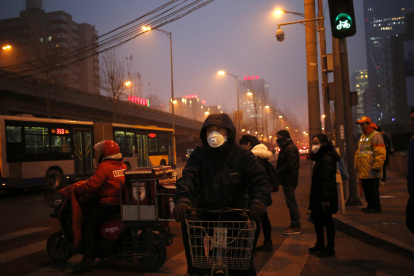 En la imagen de archivo, peatones utilizan mascarillas para protegerse de la contaminación en Pekín (China).
