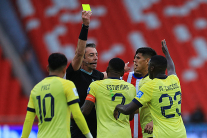 Jugadores de Ecuador discuten con el árbitro Raphael Claus una tarjeta amarilla para Pervis Estupiñán (c) en el partido Ecuador vs Paraguay