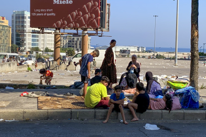 Una familia de desplazados acampa en una plaza de Beirut tras huir de bombardeos israelíes en los suburbios sur de la capital.