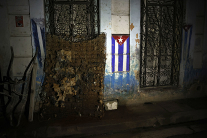 Fotografía de un colchón dañado junto a una bandera de Cuba durante un apagón este viernes, en La Habana.