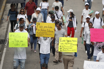 Manifestantes sostienen carteles en una marcha este sábado 19 de octubre en San Salvador (El Salvador).