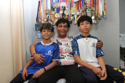 oris Villavicencio (c) muestra con orgullo las medallas que han ganado sus hijos Boris Néstor (i) y Boris Jeriel (d).