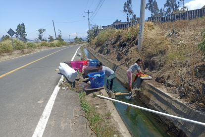 Vías. Mujeres son vistas lavando ropa al borde de las carreteras.
