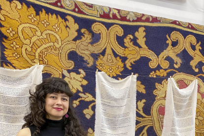 La artista colombiana Vanessa Nieto posa junto a una de sus obras expuestas en la Real Fábrica de Tapices, en el marco de la exposición "Reencuentros para tejer la vida y los afectos". EFE/Patricia Cotelo Bertaiola