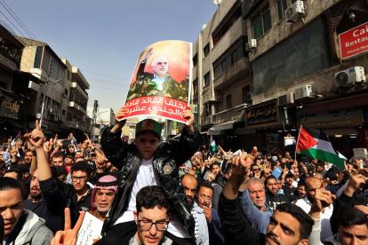 La gente grita consignas y porta pancartas que muestran al líder asesinado de Hamás, Yahya Sinwar, durante una protesta pro-palestina en Ammán, Jordania