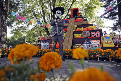 Fotografía del 19 de octubre de 2024 de un hombre disfrazado de catrín frente a una mega ofrenda de Día de Muertos, en la antigua Hacienda San Mateo del municipio de Atlixco (México).