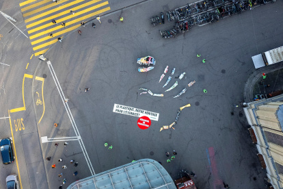 La organización medioambiental Greenpeace desplegó este martes un "fósil" de dinosaurio de una docena de metros de largo.