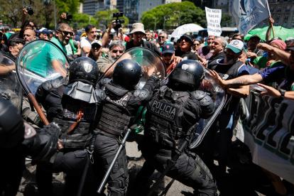 Un grupo de personas se enfrenta a la policía durante una marcha de miembros de la Asociación Trabajadores del Estado (ATE), este martes, en Buenos Aires (Argentina).