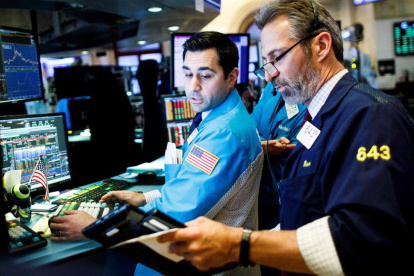 Fotografía de archivo en donde corredores de bolsa trabajan en Wall Street.