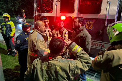 El alcalde Carlos Fernando Galán (2d), hablando con bomberos durante los trabajos de rescate este miércoles en Bogotá (Colombia).