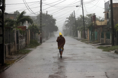 Un hombre camina en medio de la lluvia debido al paso del huracán Rafael, este miércoles, en La Habana (Cuba).