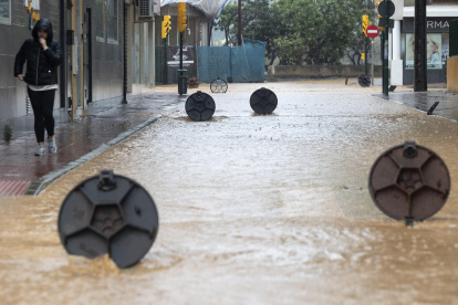 Alcantarillas abiertas en una calle de la barriada de Campanillas en Málaga, en la que el paso de la dana ha obligado a nuevos desalojos preventivos.