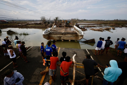 Aldeanos filipinos observan un puente dañado afectado por el tifón Usagi, en el municipio costero de Santa Ana, provincia de Cagayán, Filipinas, el 15 de noviembre de 2024.