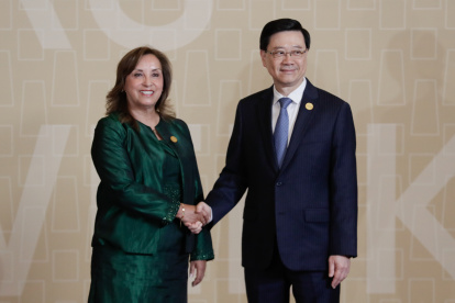 a presidenta de Perú, Dina Boluarte (i), saluda al jefe ejecutivo de Hong Kong, John Lee Ka-chiu (d).