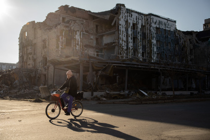 Un residente local pasa en bicicleta por una tienda y un restaurante destruidos en la ciudad de Pokrovsk, región de Donetsk, el 19 de noviembre de 2024.