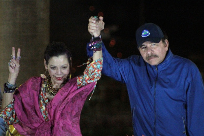 El presidente Daniel Ortega (R), y su esposa, la vicepresidenta Rosario Murillo, hacen un gesto ante la multitud durante la inauguración del paso elevado de Nejapa en Managua.