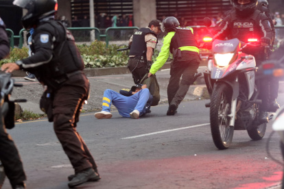 Movilización. Elementos de la Policía detienen y arrastran en la calle a uno de los manifestantes en Quito.