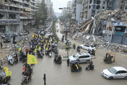 Los partidarios de Hizbulá ondean la bandera amarilla mientras desfilan en motocicletas, mientras la gente regresa para revisar sus hogares en los suburbios del sur de Beirut.