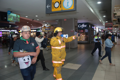 Un guía indica a través, de megáfono, la ruta de evacuación en el Terminal.