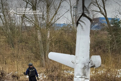 Un rescatista ucraniano supervisa la carga de los restos de un misil de crucero ruso X-55 en un camión tras un ataque con misiles en Kiev, en medio de la invasión rusa de Ucrania.