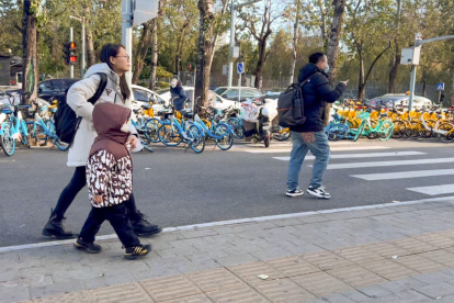 Una madre camina con su hijo camino a la escuela, en Pekín. El país, que en 2023 cedió a la India el título de nación más poblada del mundo, según la ONU