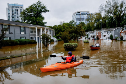 Candice Ocvil (i) y Jibri Tolen (d), residentes de Peachtree Park, remando a través de las aguas de la inundación después de que la tormenta tropical Helene atravesó Atlanta, Georgia (EE.UU.).