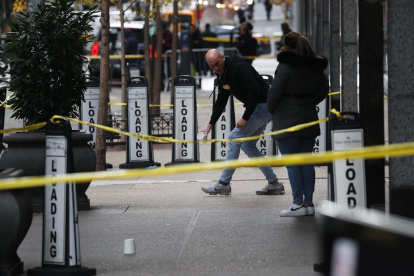 Investigadores de la policía en el lugar donde el director ejecutivo de UnitedHealthcare, Brian Thompson, fue asesinado a tiros en un aparente ataque en Nueva York.
