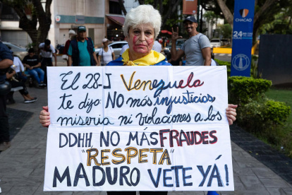 Una mujer sostiene una pancarta durante una vigilia este domingo, en Caracas (Venezuela).