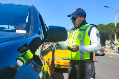 Agente civil de tránsito, en un procedimiento, en una vía en Quito.