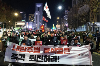 Miembros de la Confederación de Sindicatos de Corea del Sur y grupos cívicos portan una gran pancarta mientras marchan hacia la oficina presidencial durante una manifestación que pide la destitución
.