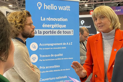 Compañía. Personas al pie de un letrero de la empresa Hello Watt.