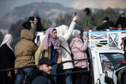 Personas celebran montadas en la parte trasera de un vehículo tras la captura de la ciudad de Damasco por parte de los rebeldes sirios.