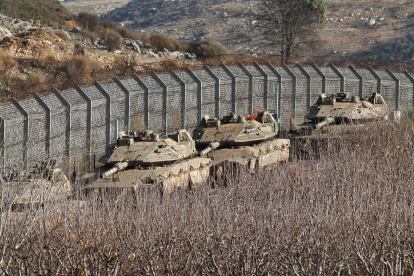 Los tanques israelíes se despliegan junto a la valla de seguridad cerca de la aldea drusa de Majdal Shams, en la frontera de Israel con Siria, en los Altos del Golán anexados por Israel tras los acontecimientos en Siria.