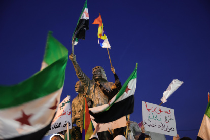 Los seguidores de la oposición siria ondean su bandera y la bandera drusa mientras celebran la toma de Damasco por parte de los rebeldes.