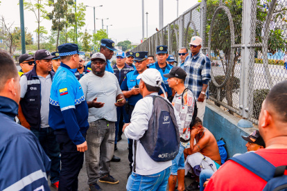 Tramitadores hablan con agentes de Control Metropolitano en los exteriores del centro de retención vehicular ubicado en la autopista Narcisa de Jesús, norte de Guayaquil.