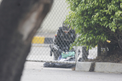Un agente policial verifica el contenido del bulto embalado hallado en el Complejo Judicial Albán Borja, en el norte de Guayaquil.