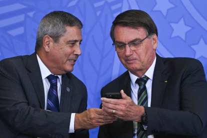 Foto de archivo, tomada el 9 de febrero de 2021, del entonces presidente de Brasil, Jair Bolsonaro (d), mientras conversa con Walter Braga Netto, quien fue ministro de la Presidencia.