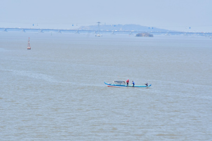 Una pequeña embarcación navega sobre el río Guayas.