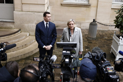 La líder del grupo parlamentario Agrupación Nacional (RN), Marine Le Pen (D), y el presidente del partido, Jordan Bardella (I), hablan con los medios al salir del Hotel Matignon en París, el 16 de diciembre de 2024.