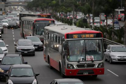 Varios buses de transporte público y vehículos particulares tratando de avanzar a lo largo de la transitada avenida Javier Prado en Lima (Perú).