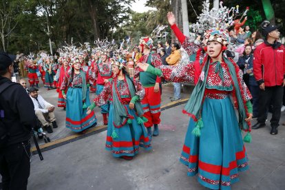 Integrantes de una comparsa bailan música navideña durante el primer día de novenas este lunes, en Bogotá (Colombia).