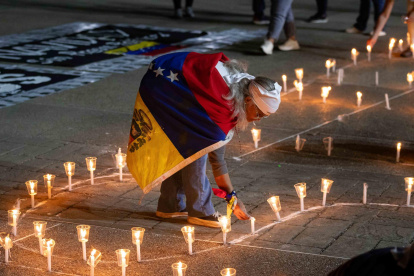 Una mujer enciende una vela durante una vigilia por los "presos políticos" en la Universidad Central de Venezuela (UCV) este martes, en Caracas (Venezuela).
