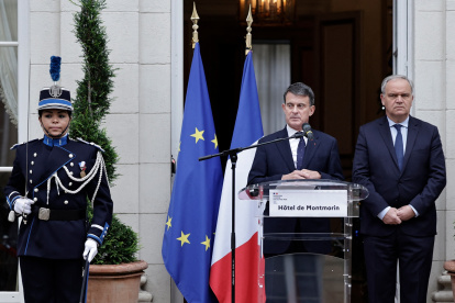 El recién nombrado Ministro de Ultramar, Manuel Valls (C), pronuncia un discurso acompañado por el Ministro saliente adjunto al Ministro del Interior, Francois-Noel Buffet