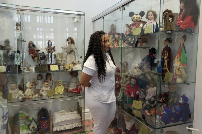 otografía del 15 de diciembre de 2024 de una mujer observando la colección de la casa de muñecas "Un momento de fantasía" en Cartagena (Colombia).