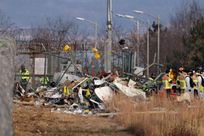 Se ven restos del avión de Jeju Air en el aeropuerto internacional de Muan en Muan, a 288 kilómetros al suroeste de Seúl, Corea del Sur, este domingo 29 de diciembre de 2024.