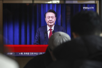 Una pantalla de televisión muestra una transmisión en vivo del presidente de Corea del Sur, Yoon Suk Yeol, dirigiéndose a la nación.