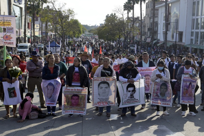 Familiares de las víctimas de Ayotzinapa sostienen retratos de los estudiantes desaparecidos mientras participan en una peregrinación frente a la Basílica de Nuestra Señora de Guadalupe.