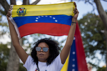 Una mujer sostiene una bandera de Venezuela. El 10 de enero está previsto la posesión presidencial.