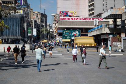 Varias personas caminan por una calle este martes, en Caracas (Venezuela).